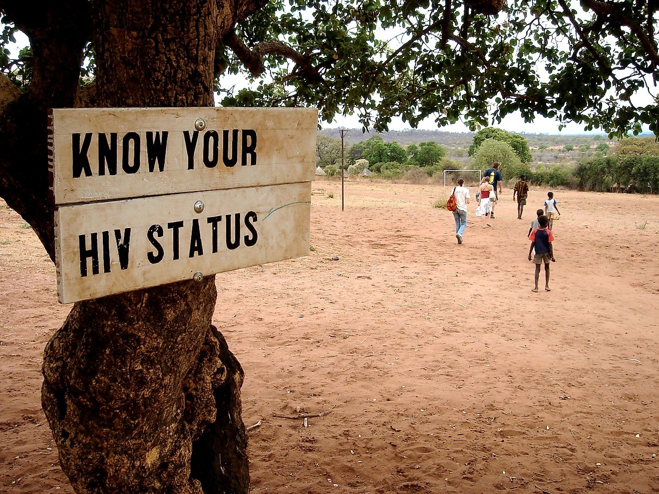A signboard attached to a tree in an African nation informing residents about the need to screen for HIV.