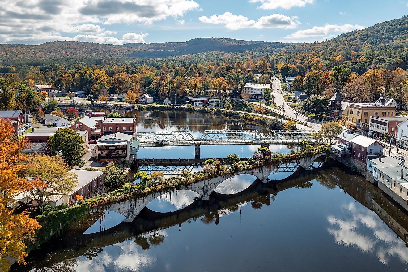 The Bridge of Flowers spans the Deerfield River with the rolling hills of Western Massachusetts as a backdrop in Shelburne, MA during fall.