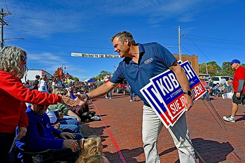 Former Kansas Secretary of State Kris Kobach shakes hands with festival attendees during the annual Maple Leaf Festival parade in Baldwin City. - mark reinstein / Shutterstock.com